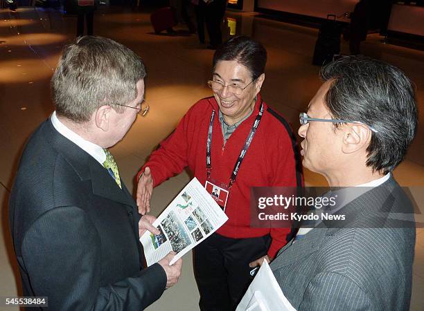 Britain - Masato Mizuno , vice president of the Japanese Olympic Committee, hands out a leaflet in London on April 3 emphasizing the safeness of...