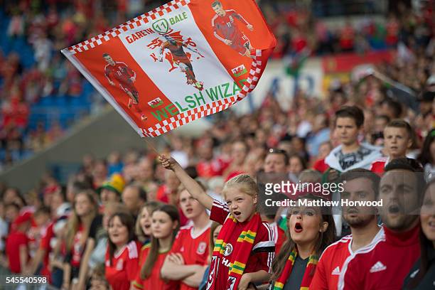 Wales fan waves a flag during a ceremony at the Cardiff City Stadium on July 8, 2016 in Cardiff, Wales. The players toured the streets of Cardiff in...