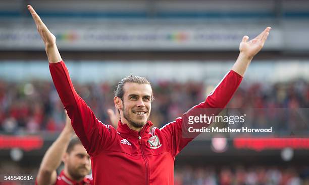 Wales' Gareth Bale applauds the crowd during a ceremony at the Cardiff City Stadium on July 8, 2016 in Cardiff, Wales. The players toured the streets...