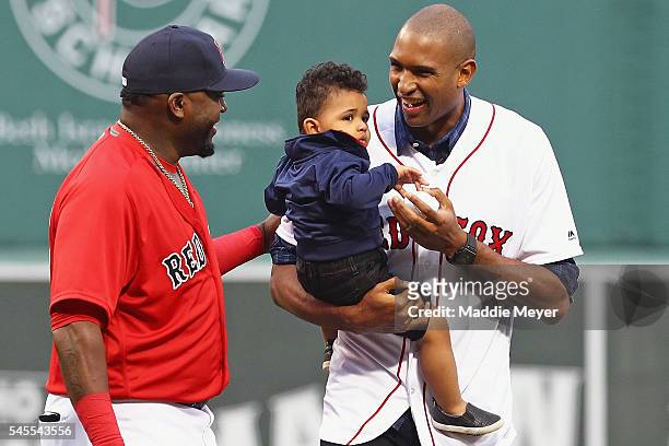 Al Horford of the Boston Celtics, holding his son Ean, talks with David Ortiz of the Boston Red Sox after throwing out the first pitch before the...