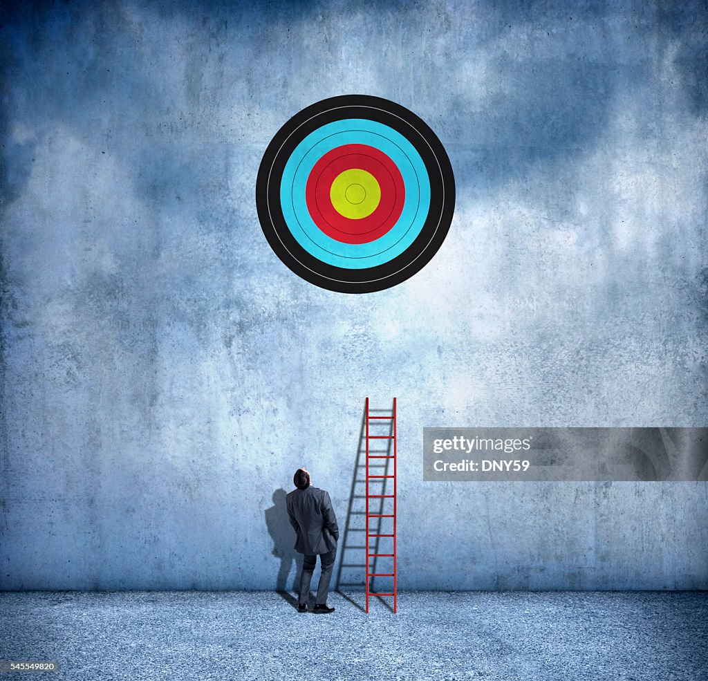 Businessman About To Use Ladder To Reach Target