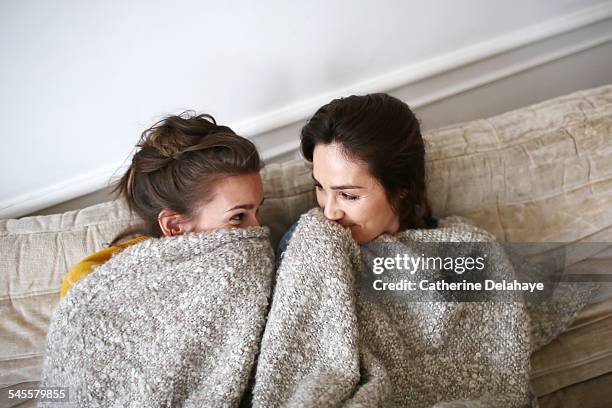 two friends laughing together - blanket stock pictures, royalty-free photos & images