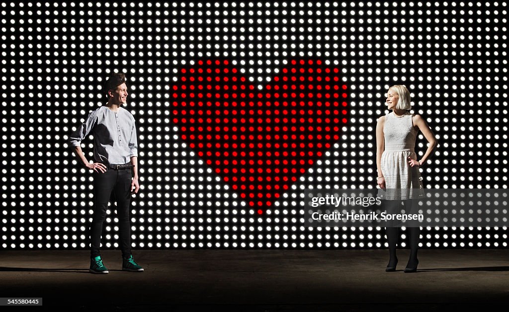 Couple in front of lightwall with heartheart