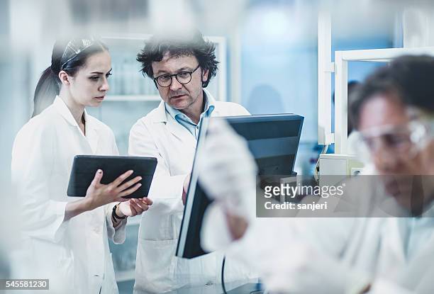 científicos que trabajan en el laboratorio. - química fotografías e imágenes de stock