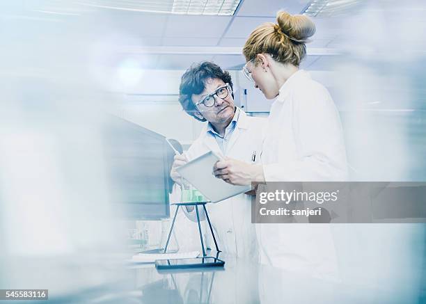 scientifique travaillant au laboratoire - flouté photos et images de collection