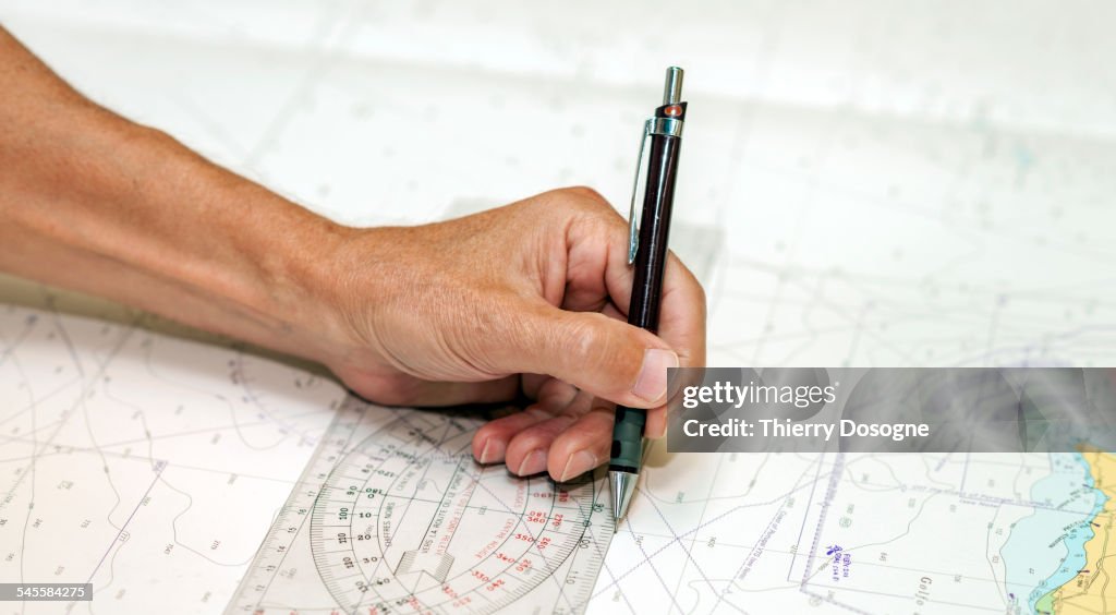Captain drawing road on navigational map