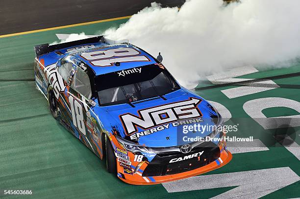 Kyle Busch, driver of the NOS Energy Drink Toyota, celebrates with a burnout after winning the NASCAR XFINITY Series ALSCO 300 at Kentucky Speedway...
