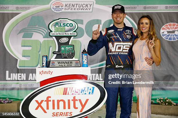 Kyle Busch, driver of the NOS Energy Drink Toyota, poses with wife Samantha Busch in Victory Lane after winning the NASCAR XFINITY Series ALSCO 300...