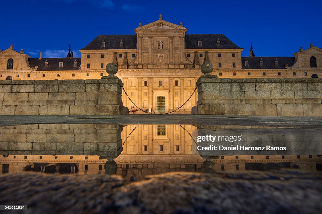 Twilight photo of the main entrance to the Monasterio de El Escorial, reflected in the water Madrid. Spain