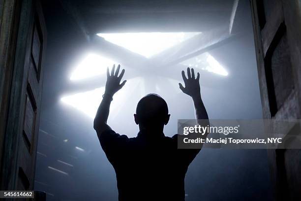 silhouette of a man with raised hands against light coming from above. - religion imagens e fotografias de stock