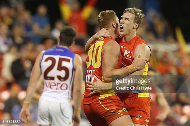 Peter Wright of the Suns celebrates a goal with team mates Tom Lynch during the round 16 AFL match between the Gold Coast Suns and the Brisbane Lions...