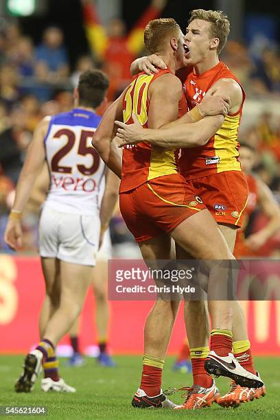 Peter Wright of the Suns celebrates a goal with team mates Tom Lynch during the round 16 AFL match between the Gold Coast Suns and the Brisbane Lions...