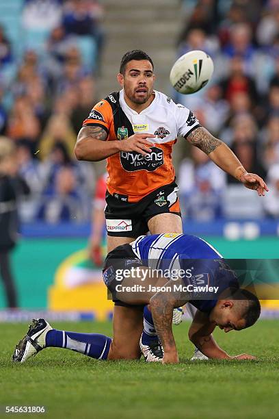 Dene Halatau of the Tigers passes the ball during the round 18 NRL match between the Canterbury Bulldogs and the Wests Tigers at ANZ Stadium on July...