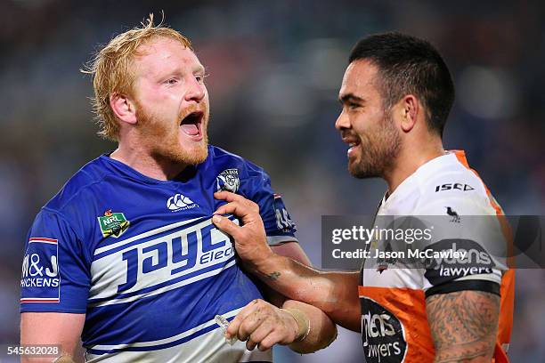 James Graham of the Bulldogs is held back by Dene Halatau of the Tigers during the round 18 NRL match between the Canterbury Bulldogs and the Wests...