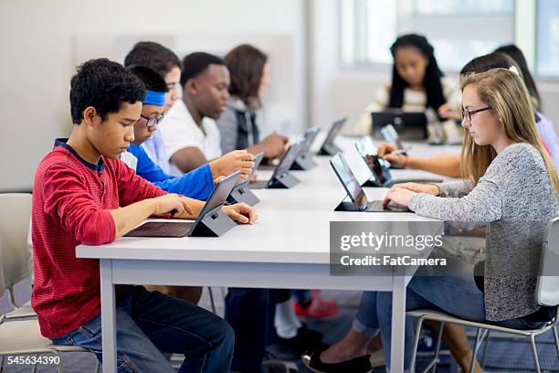 escribiendo en un comprimido - computer lab fotografías e imágenes de stock