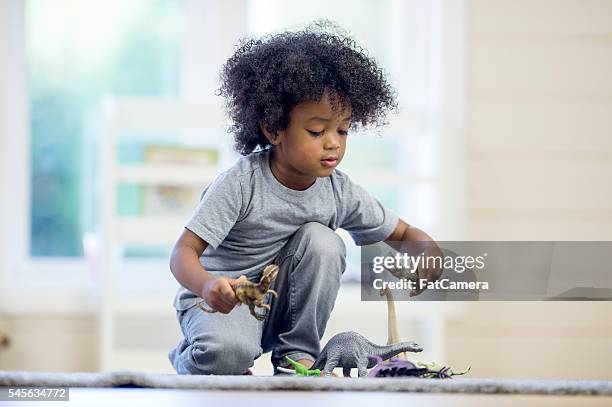 恐竜と遊ぶ小さな男の子 - 動物のおもちゃ ストックフォトと画像