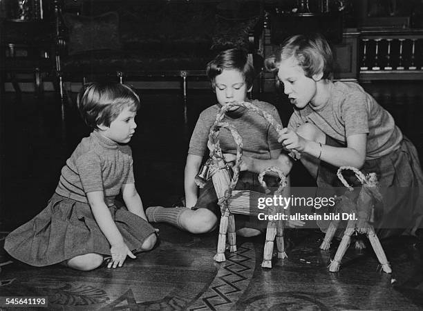 Prinzessin, Königin von Dänemark seit 1972-mit ihren Schwestern Anne und Benedikte beim Spielen mit schwedischen, aus Stroh geflochtenen Julböcken-...