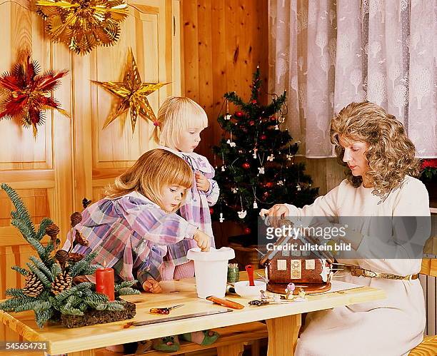 Mutter bastelt mit Kindern ein Lebkuchenhaus- 1994