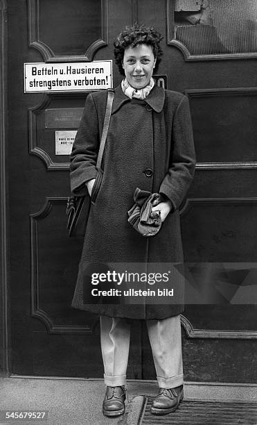 Schauspielerin, Deutschlandvor einer Haustür mit dem Schild:'Betteln und Hausieren strengstensverboten'- 1947Fotograf: Fritz Eschen