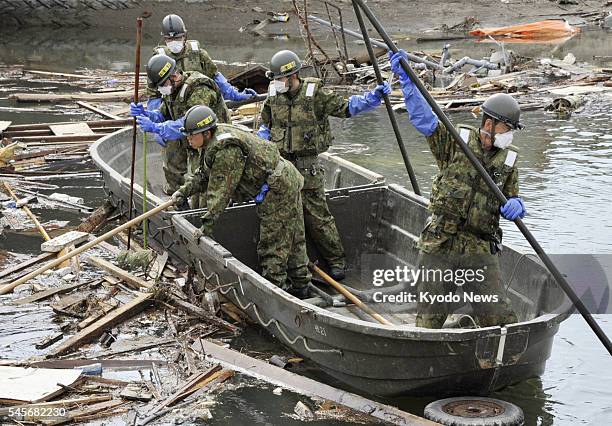 Japan - Members of Self-Defense Forces on a boat search for people missing since the March 11 earthquake and tsunami, in the city of...