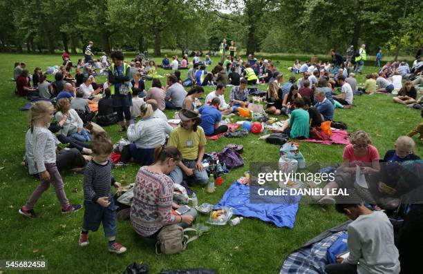 People use a European Union flag as a blanket while taking part during a picnic against Brexit organised by the General Assembly in Green Park in...