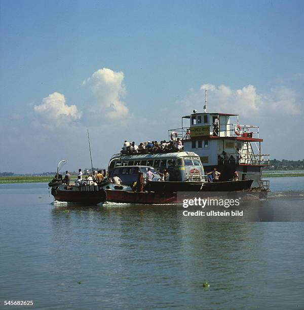 Mit einem Bus, Menschen und anderen Fahrzeugen beladene Fähre auf dem Fluss Meghna- 1999