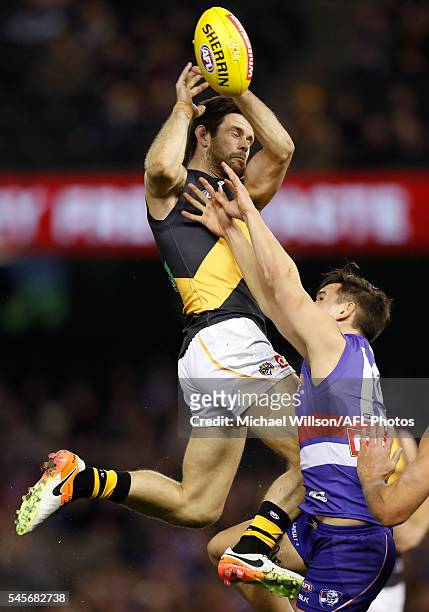 Trent Cotchin of the Tigers attempts to mark over Lukas Webb of the Bulldogs during the 2016 AFL Round 16 match between the Western Bulldogs and the...