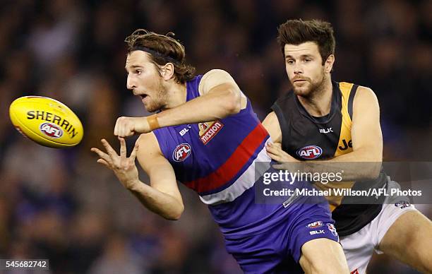 Marcus Bontempelli of the Bulldogs is tackled by Trent Cotchin of the Tigers during the 2016 AFL Round 16 match between the Western Bulldogs and the...