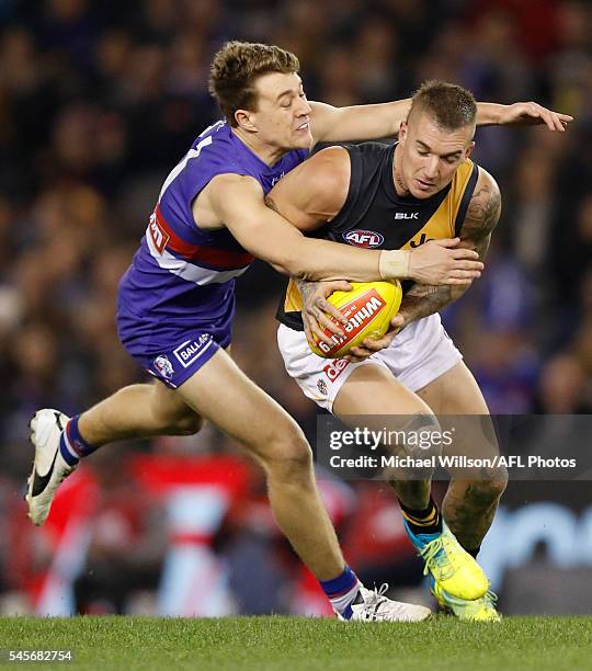 Dustin Martin of the Tigers is tackled by Jack Macrae of the Bulldogs during the 2016 AFL Round 16 match between the Western Bulldogs and the...