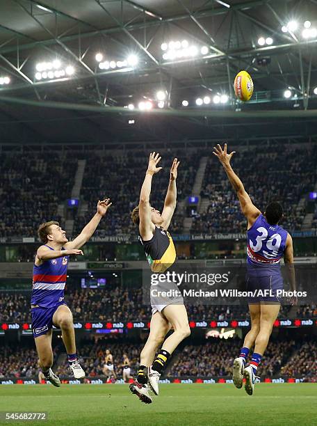 Jack Macrae of the Bulldogs, David Astbury of the Tigers and Jason Johannisen of the Bulldogs compete for the ball during the 2016 AFL Round 16 match...