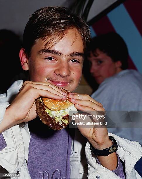 Junge isst einen Hamburger- 1994