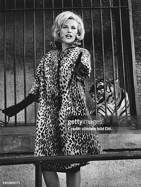 Johns, Bibi *-Schlagersaengerin, Schauspielerin, S- im Pelzmantel vor einem Tigerkaefig- 1963