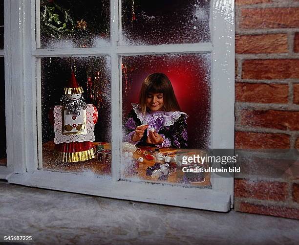 Kind bei weihnachtlichen Bastelarbeitenam Fenster- o.J.