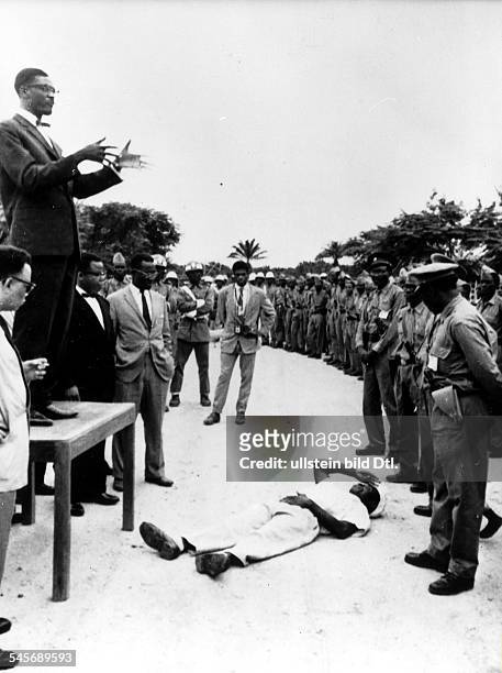 Congolese political leader. Prime Minister Lumumba delivering a speech in Stanleyville, Congo, 19 July 1960. A Congolese citizen lies supine before...