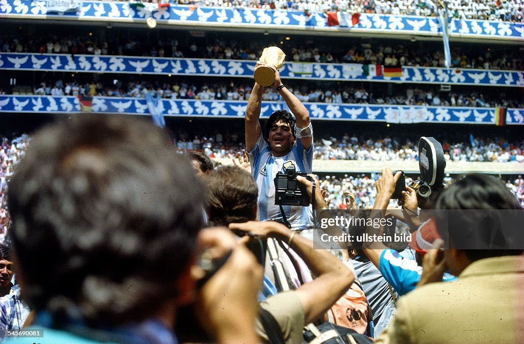 1986 FIFA World Cup in Mexico Final in Mexico City: Argentina 3 - 2 Germany - Argentine captain Diego Maradona with the World Cup trophy amid photographers -