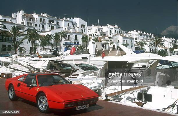 Jachthafen Puerto Banus in Marbella, am Kai steht ein roter Ferrari- 2000