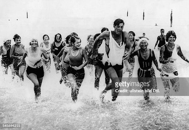 Weissmueller, Johnny *-+Schauspieler, Schwimmsportler, USATarzan-Darsteller, Fuenffacher Olympiasieger- mit seinen 'Verehrerinnen' am Strand vonMiami...