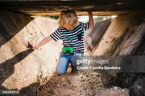 Boy playing under ditch