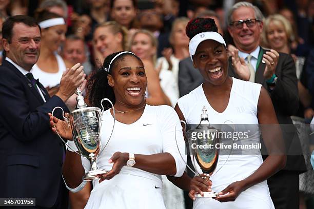 Venus Williams of The United States and Serena Williams of The United States hold their trophies following victory in the Ladies Doubles Final...