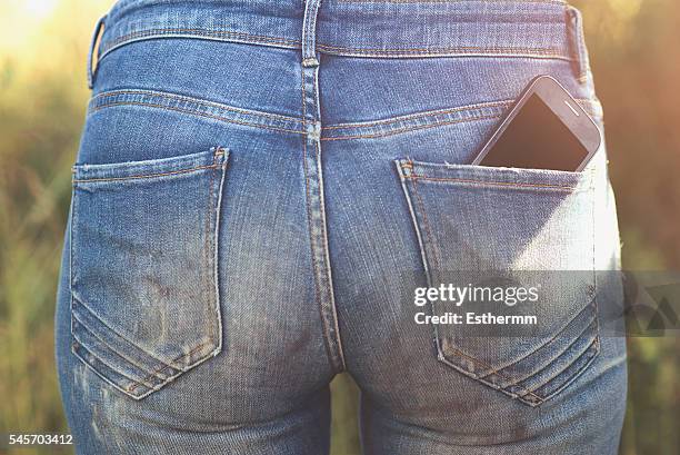 close-up of a mobile phone in a back pocket - bolso traseiro imagens e fotografias de stock