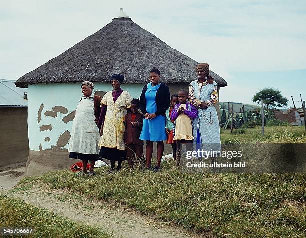 Xhosa - Frauen mit ihren Kindern voreinem traditionellen Rundhaus in derTranskei - o.J.