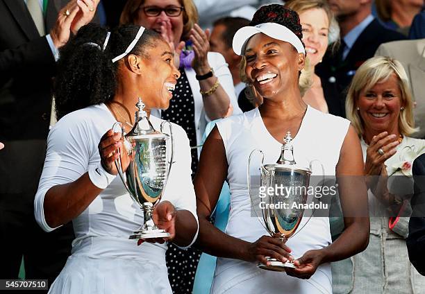 Venus and Serena Williams of USA celebrate with their winners' trophies after beating Timea Babos of Hungary and Yaroslava Shvedova of Kazakstan in...