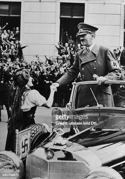 Adolf Hitler begrüsst ein sudetendeutschesMädchen in Landestracht bei der Ankunftvor der Reichskanzlei