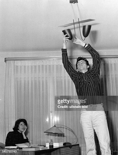 Schauspieler, Dmit seiner Ehefrau Miriam Bru beim Aufhängen einer Lampe in seinem Haus