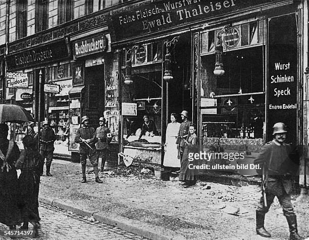 Ein Lebensmittelgeschäft in Berlinwird nach der Plünderung derSchaufenster von Militär bewacht- 1919