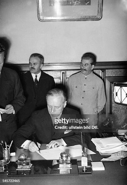 Reichsaussenminister Joachim v. Ribbentropbei der Unterzeichnung des Vertrages imMoskauer Kreml; im Hintergrund von links:der sowjetische Botschafter...