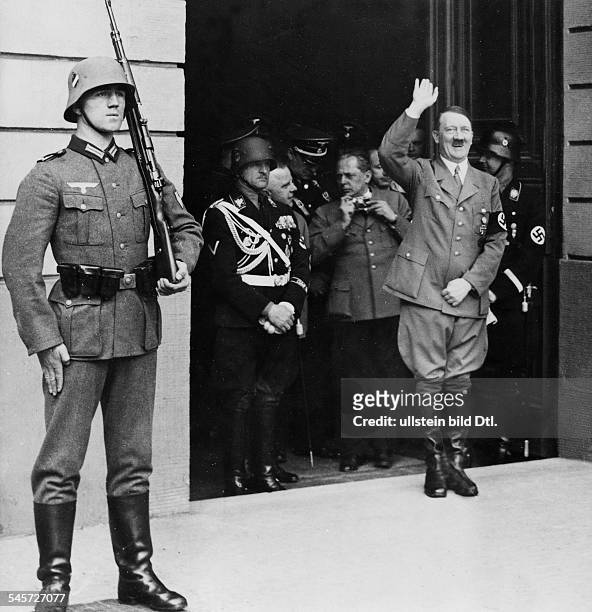 Adolf Hitler grüsst vom Eingang der Reichskanzlei die Menge. Rechts hinterihm Heinrich Himmler, links der FotografHeinrich Hoffmann; ganz links:...