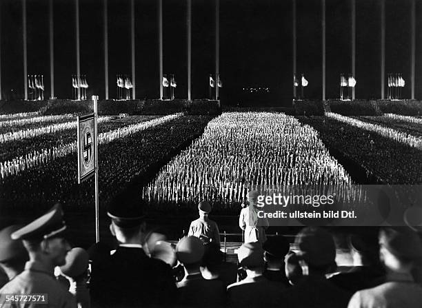 German Chancellor Adolf Hitler speaking at the annual Nazi Party rally at Zeppelin Field, Nuremberg, Germany. In the background is the 'Cathedral of...