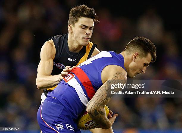 Clay Smith of the Bulldogs is tackled by Oleg Markov of the Tigers during the 2016 AFL Round 16 match between the Western Bulldogs and the Richmond...