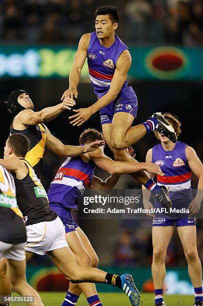 Lin Jong of the Bulldogs jumps over opponents during the 2016 AFL Round 16 match between the Western Bulldogs and the Richmond Tigers at Etihad...